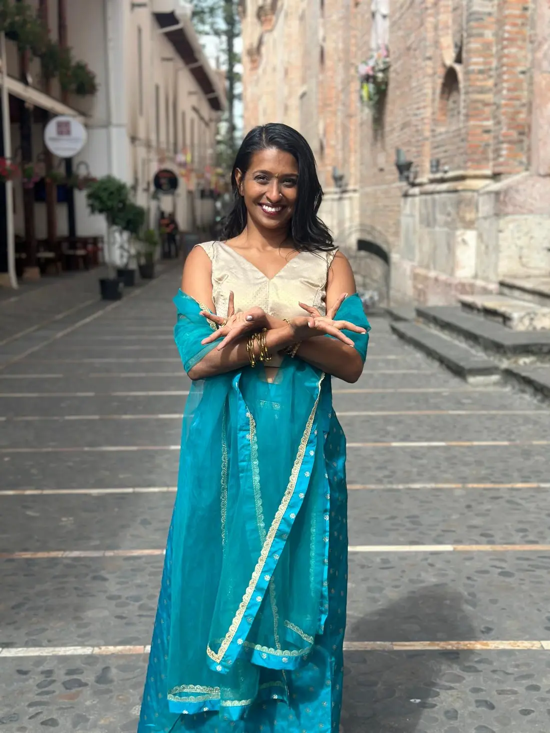 Santhra holding an expressive hand gesture on a sunlit street